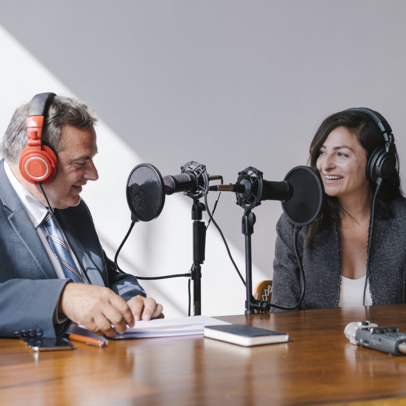 How Podcasts Help CEOs Build Influence and Visibility article image banenr featuring two office workers on a podcast