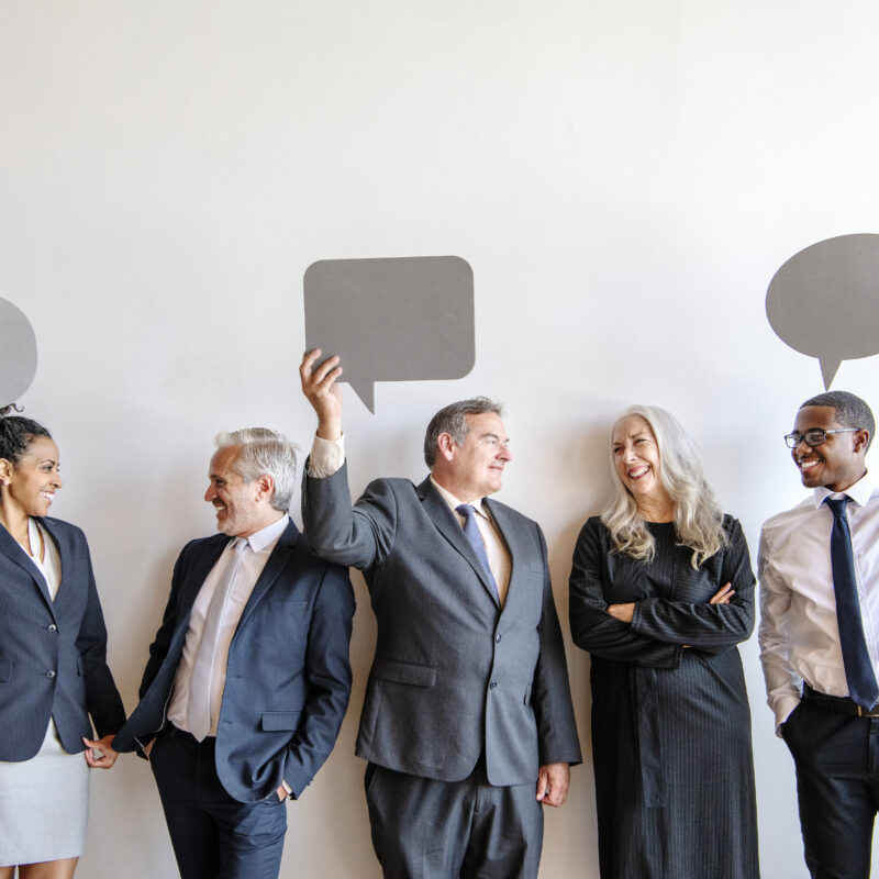 How to Enhance an Active Executive’s Social Media Strategy article banner featuring group of office workers holding up speech bubble signs