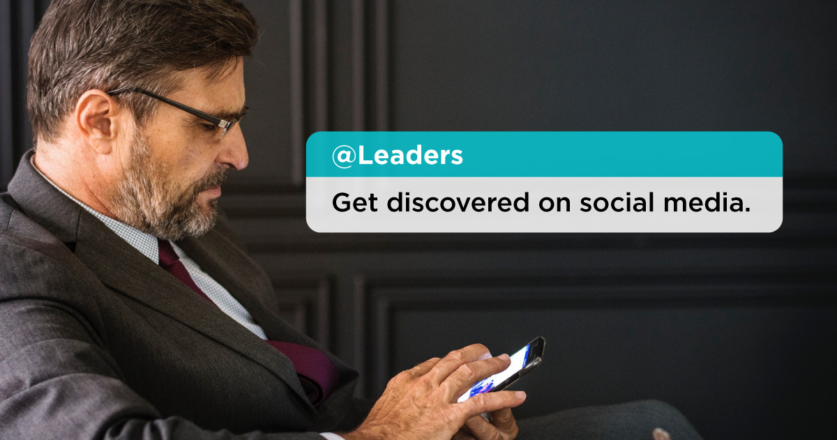 A middle-aged man wearing a suit using a smart phone. On the image there is a notification that says "@Leaders - Get discovered on social media." Influential Executive How to Get Discovered on Social Media by Stakeholders.