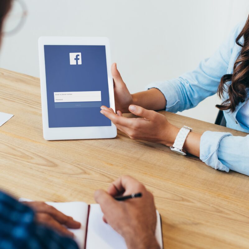 Is Facebook Relevant for Executive Social Media? article image featuring woman holding tablet with facebook app on screen